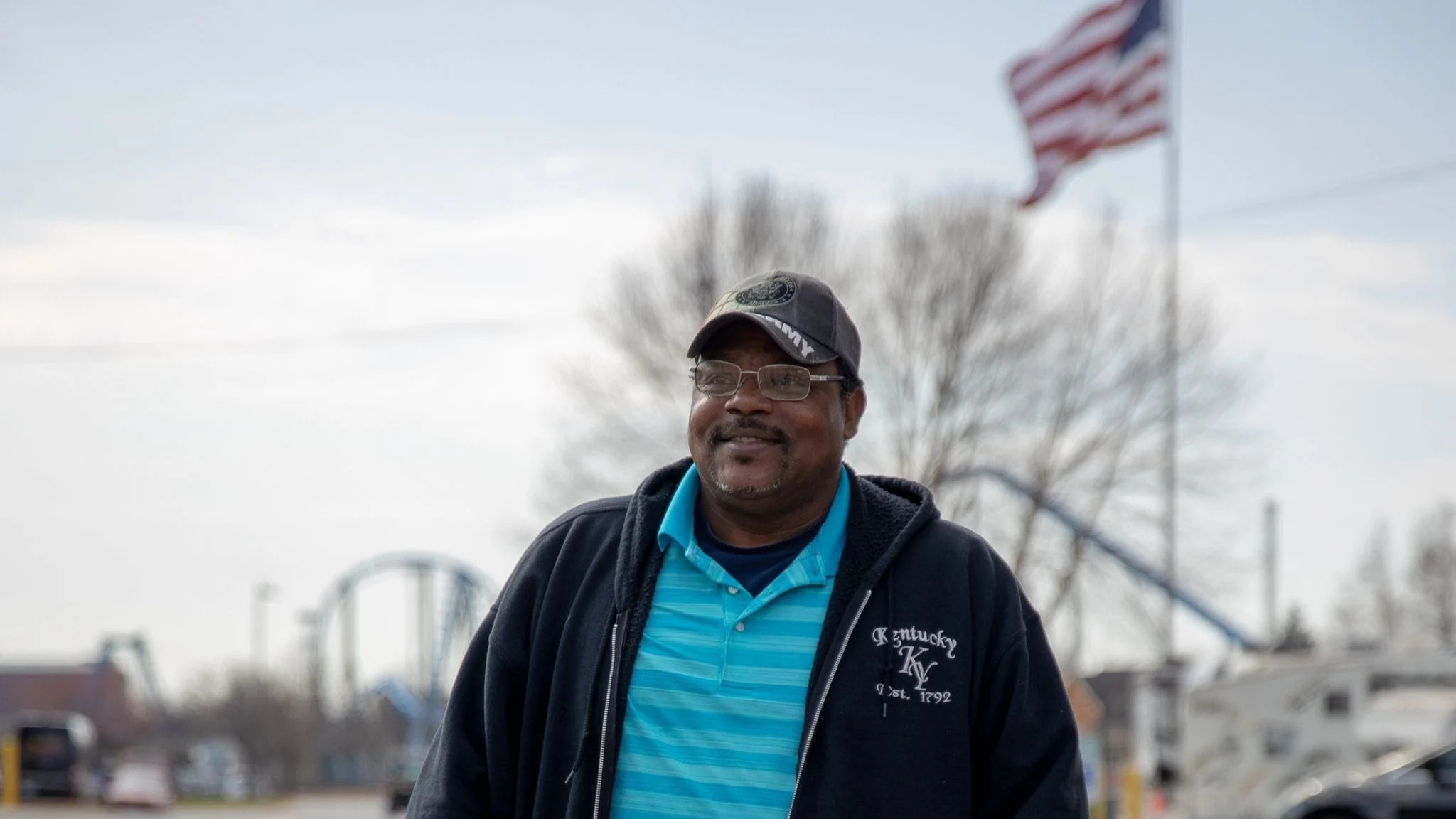 Man standing with american flag in the background.