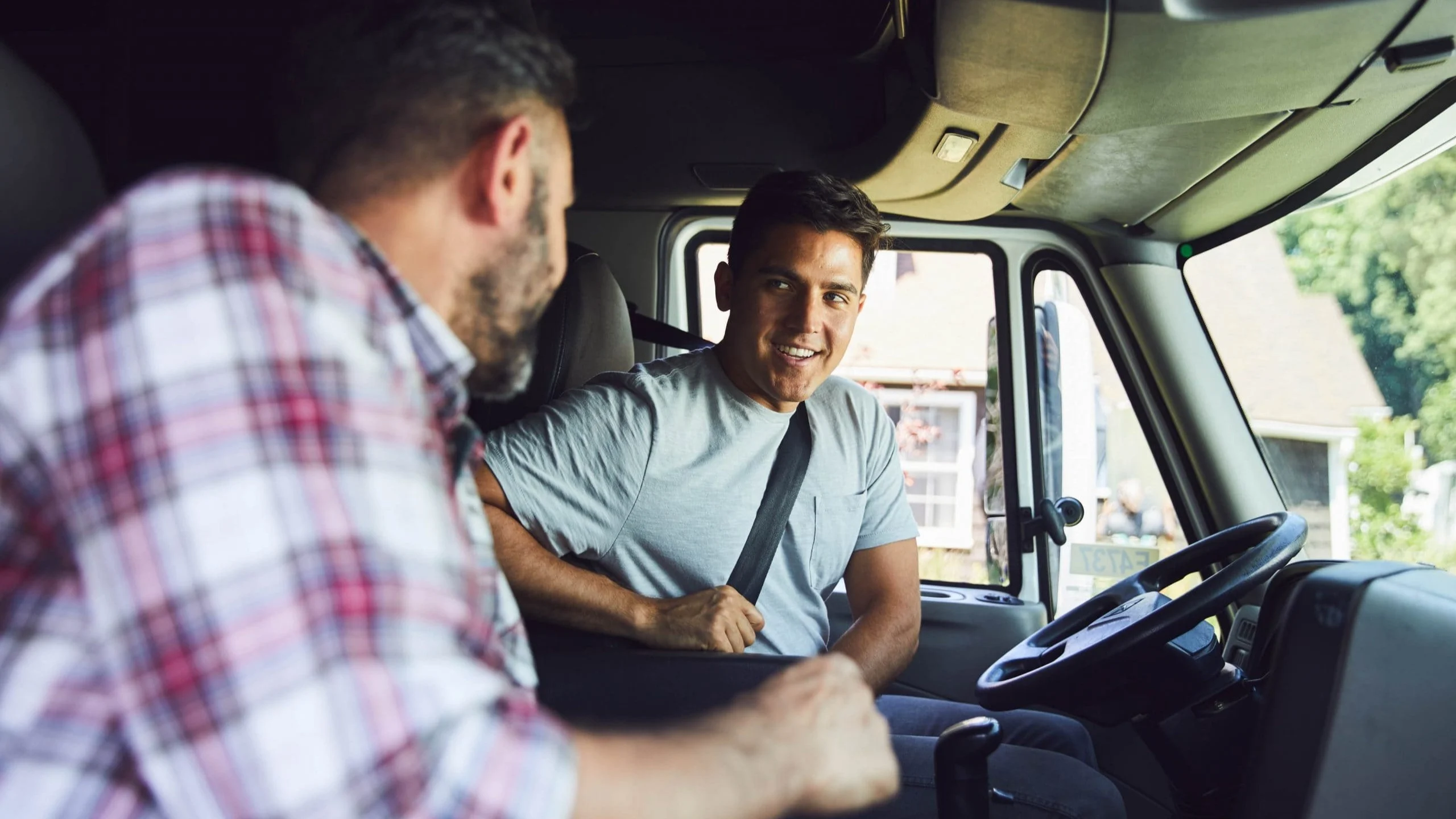 Two men talking in truck.