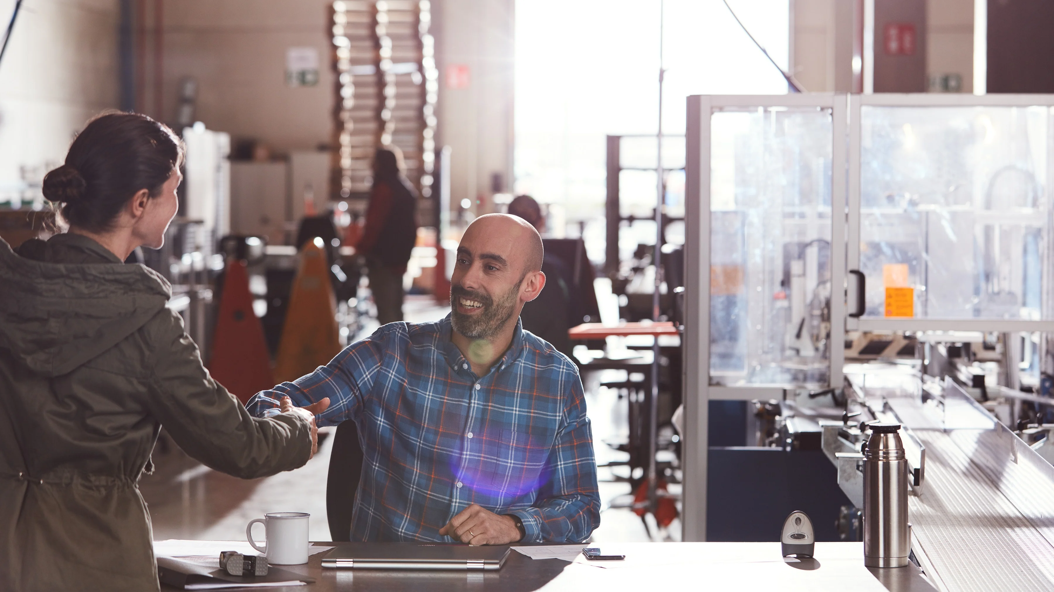 Two people shaking hands in a warehouse