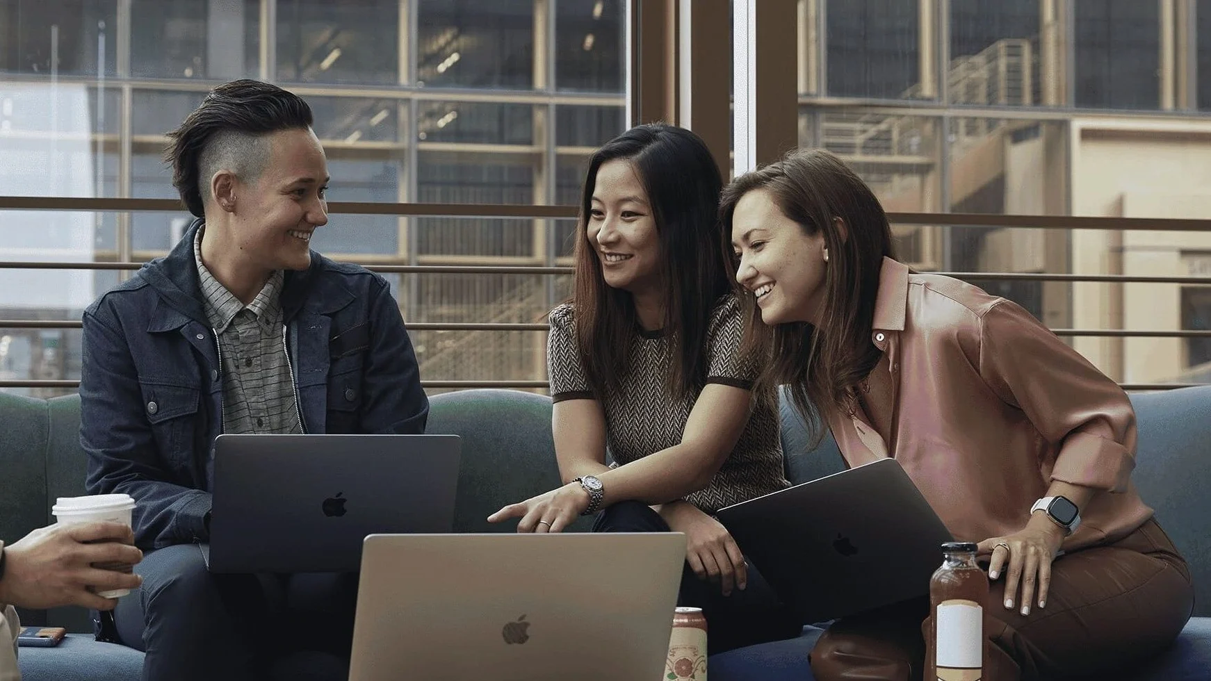 Employees in meeting with laptops