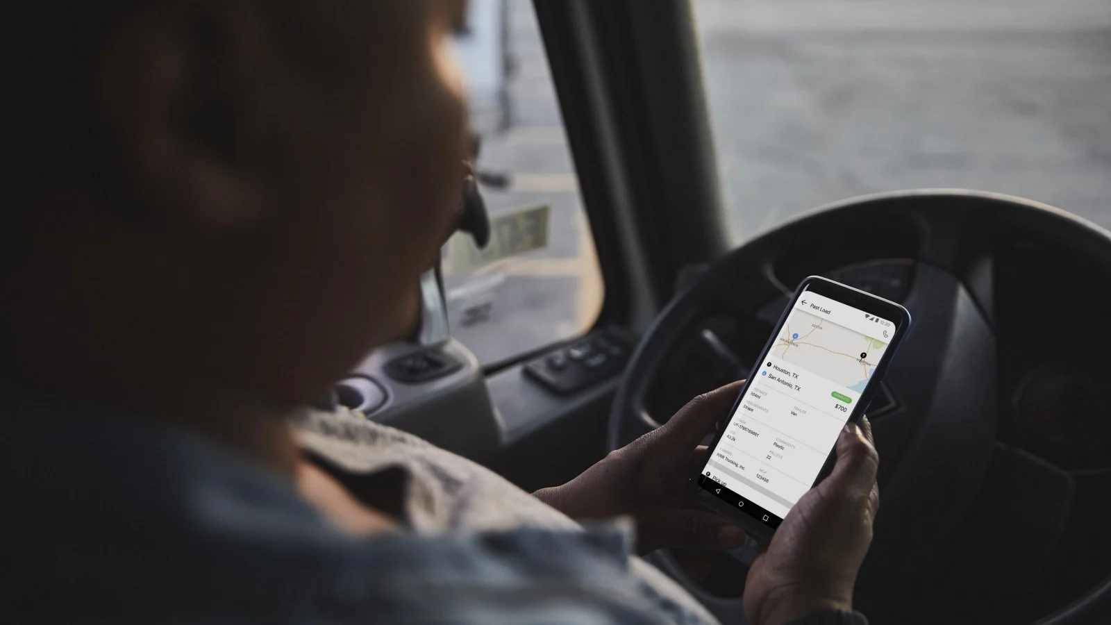 Person holding phone in truck.