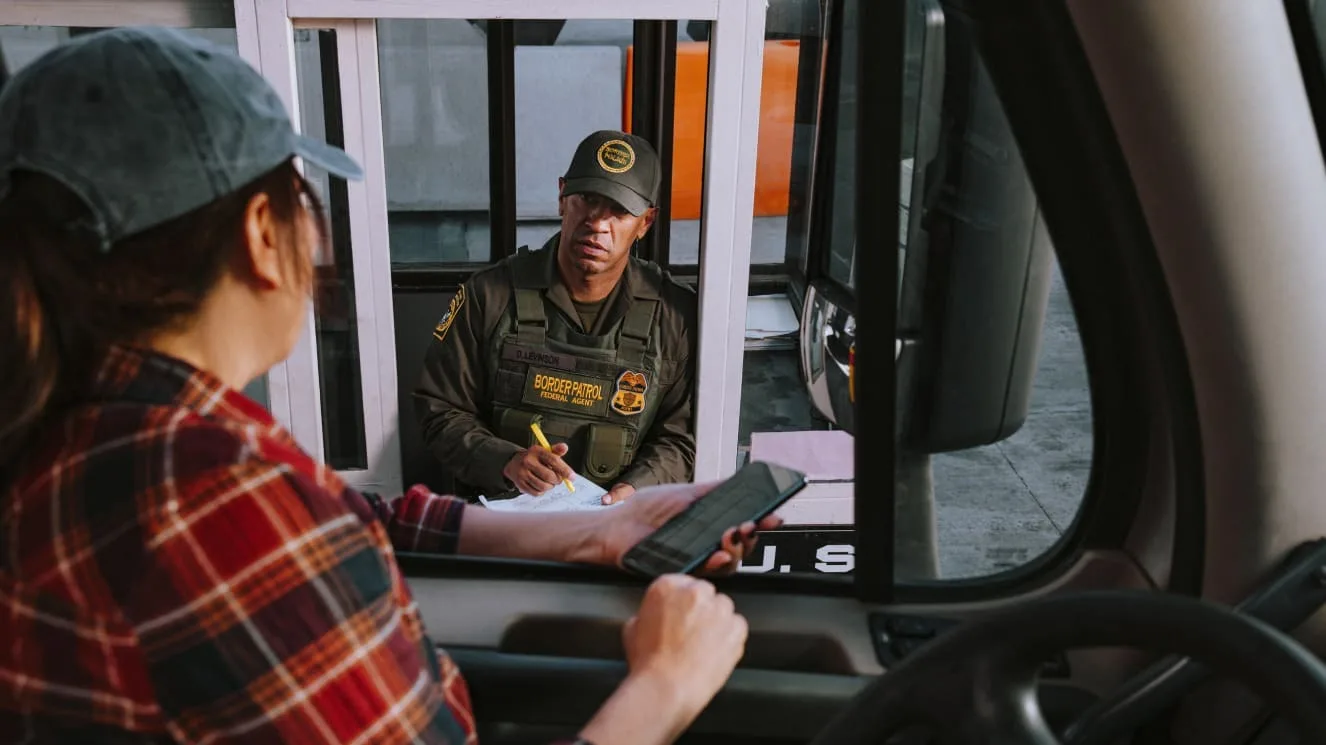 Female trucker speaking to border agent