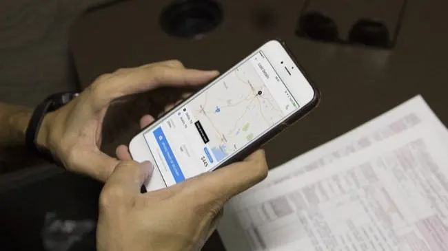 Man looking at shipping software on phone.