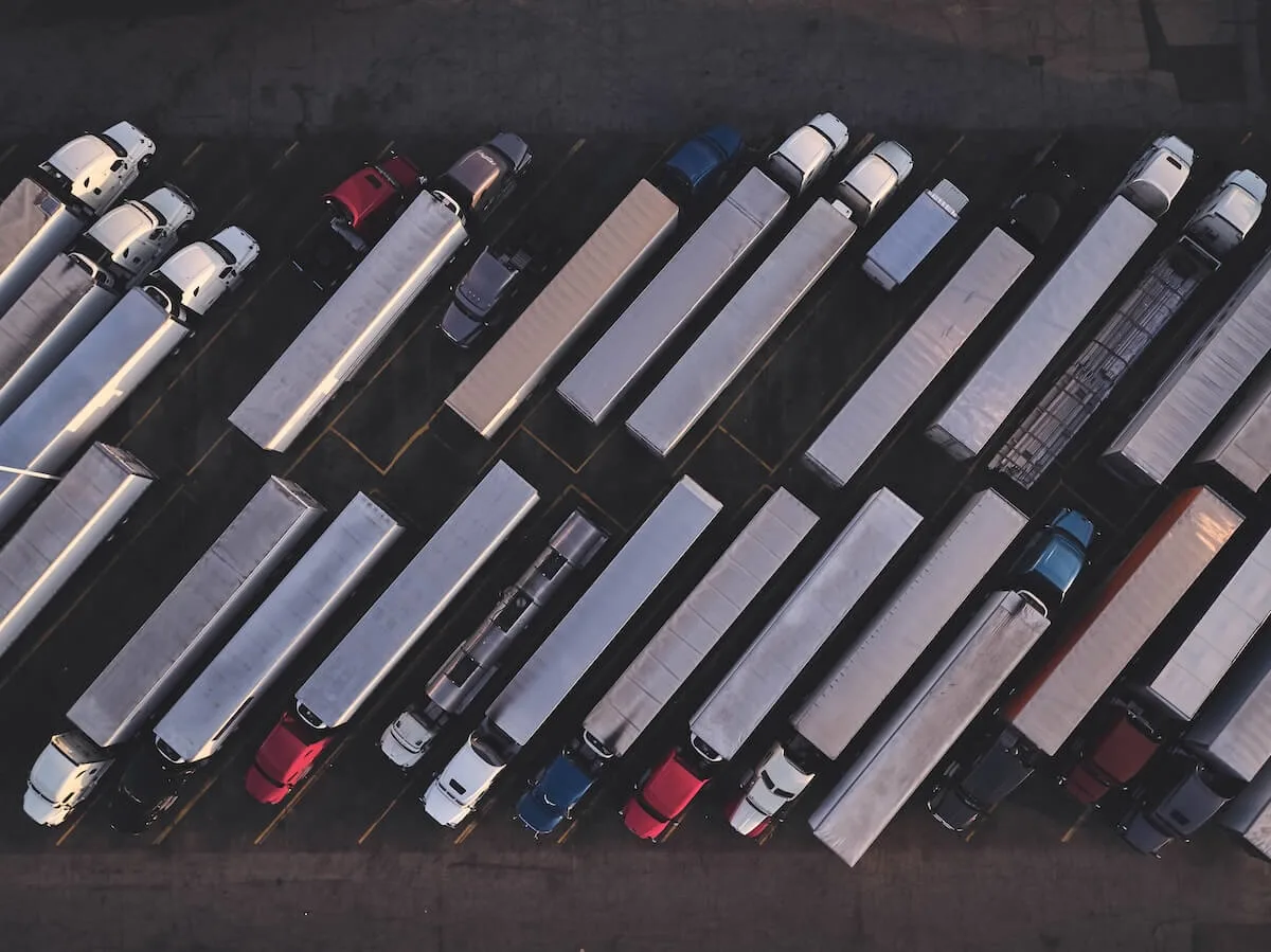 Ariel view of parked trucks of different sizes and colors at a truck stop