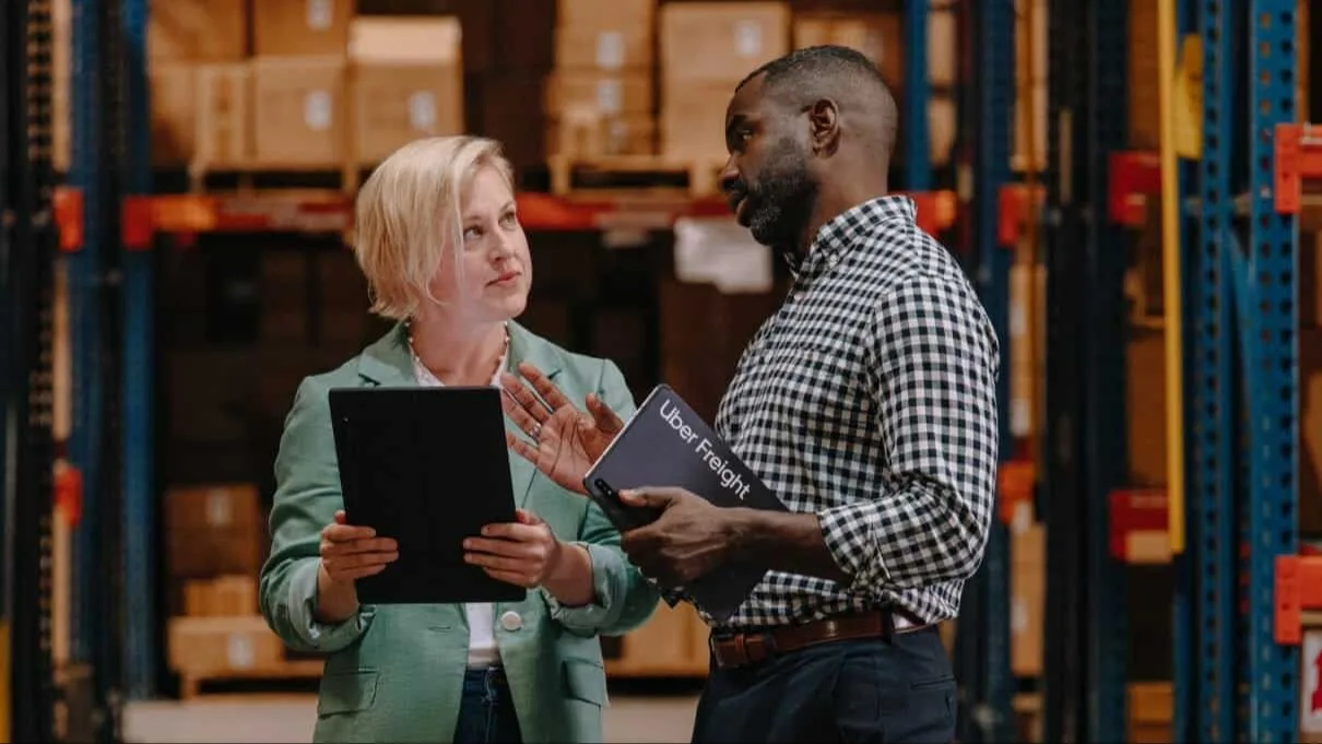 Two people having a discussion in a warehouse.