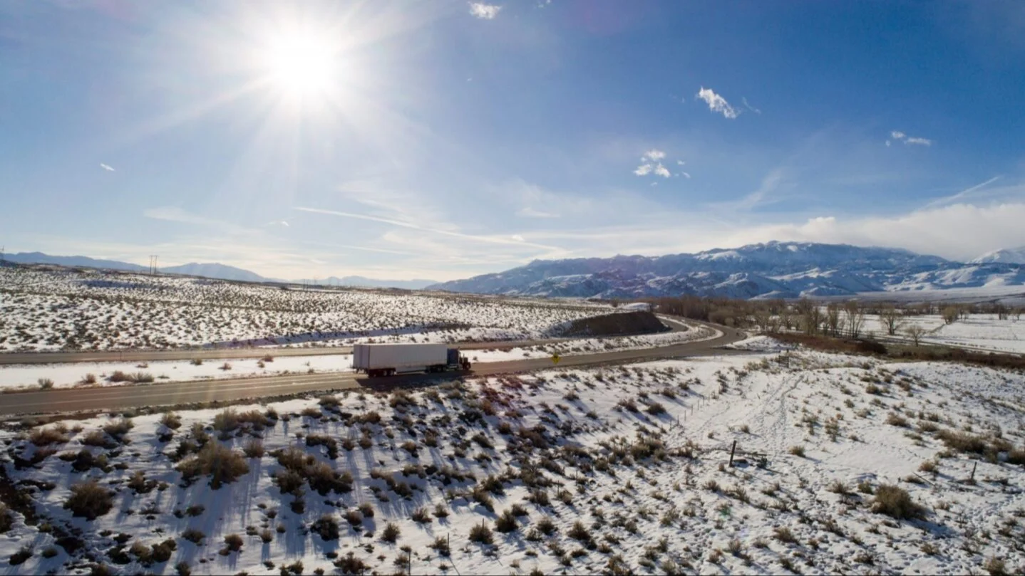 Truck driving on snowy road.