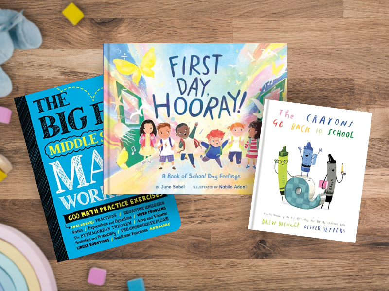 Three back to school books on wooden surface with colorful learning blocks:The Big Fat Middle School Math Workbook (blue cover with doodles) , First Day, Hooray! A Book of School Day Feelings (rainbow on bothe the right and left side with a blue sky and a diverse group of kids walking together with butterflies and birds around them), and The Crayons Go Back to School (white cover with crayon characters with school supplies).