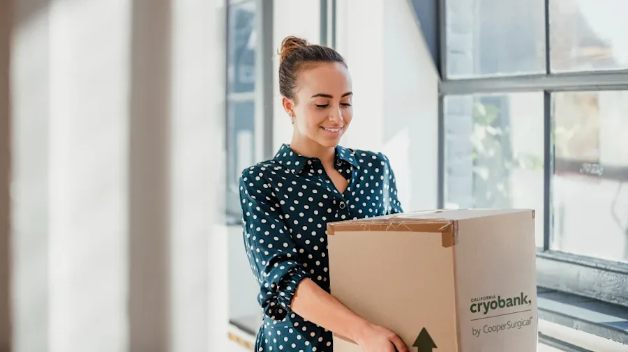 A female holding a California Cryobank box, smiling.