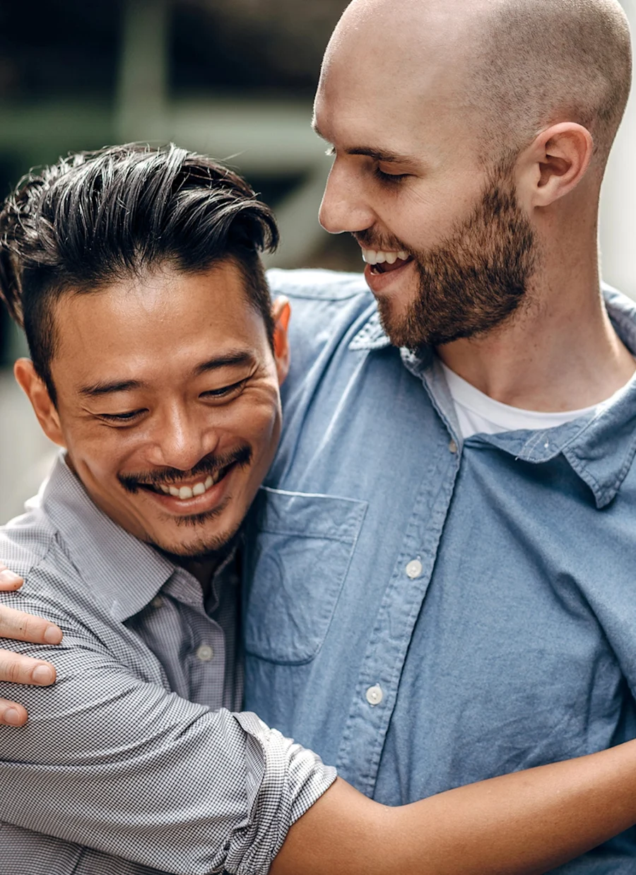 A male couple hugging.