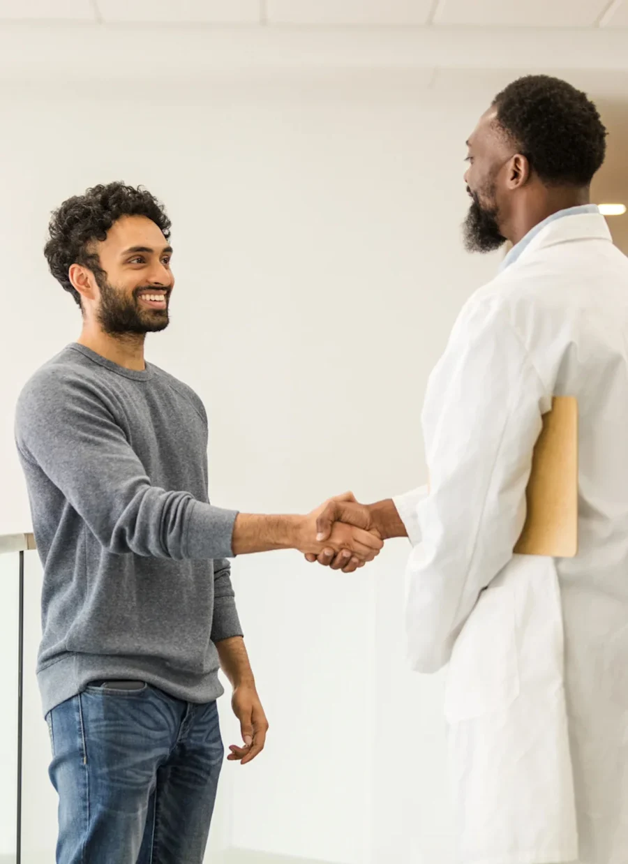 Two people shaking hands and smiling.