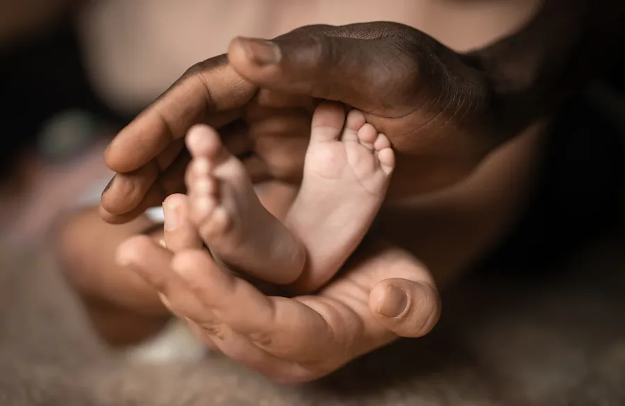 Hands surrounding an infant's feet.