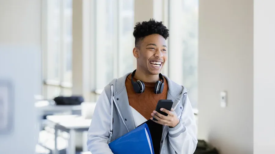 Happy smiling male holding a phone and folder with documents.