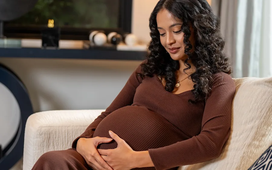 A mother holding her pregnant belly.