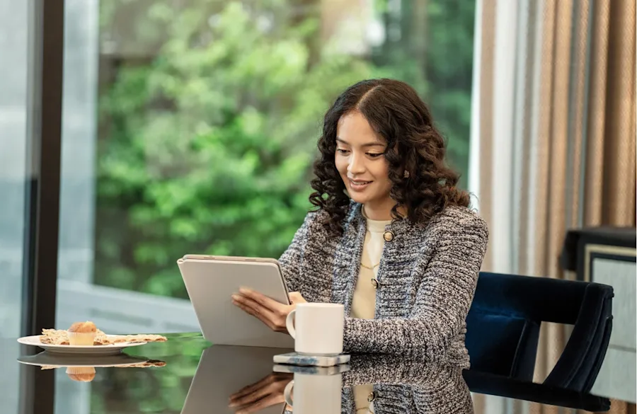 A female smiling at a notebook in an office setting. 