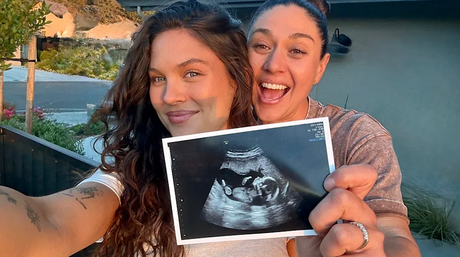 Emily and Lauren holding a photo of an ultrasound.