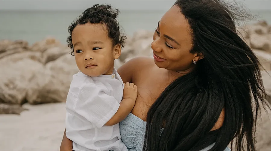 A mother holding her child, smiling.