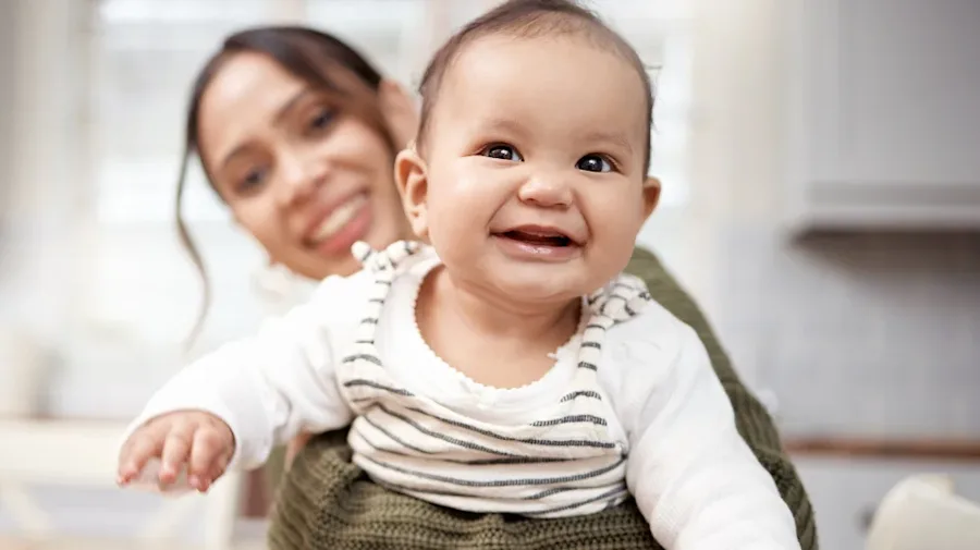 A parent holding their child with big smiles.