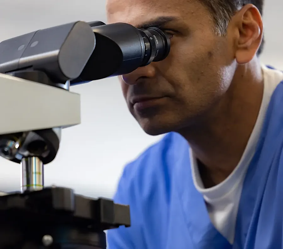 Doctor looking through a microscope.