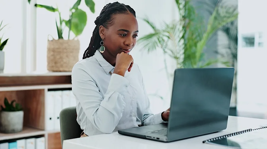 A person seated at a desk with a laptop.
