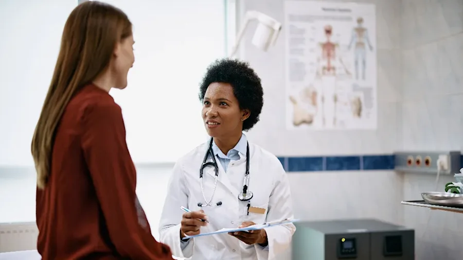 A female having a conversation with a doctor in an office.