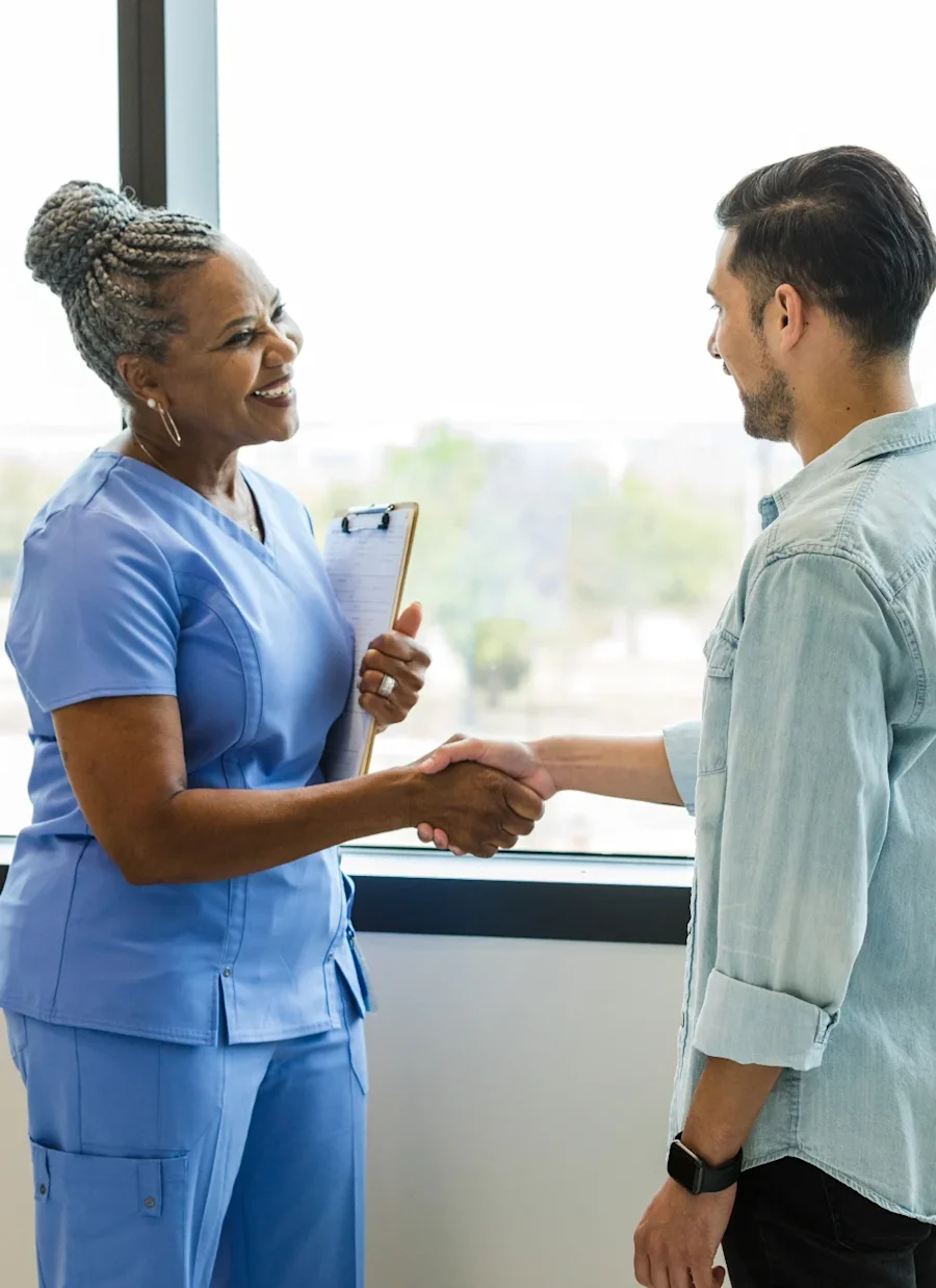 One person shaking hands with a medical professional smiling.