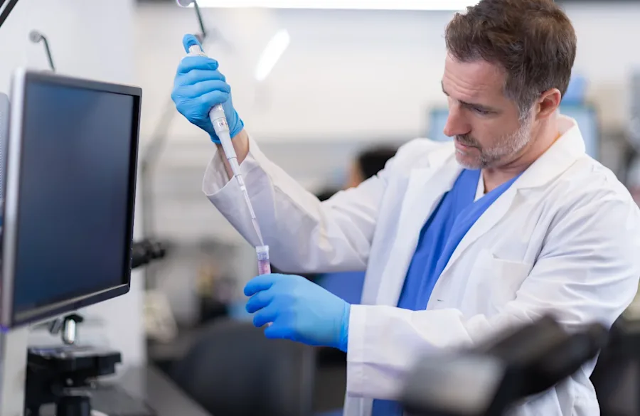 A medical professional handing equipment in a lab. 