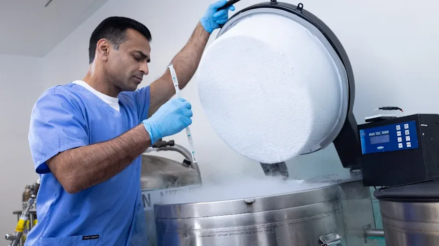 A person checking vials in a lab.