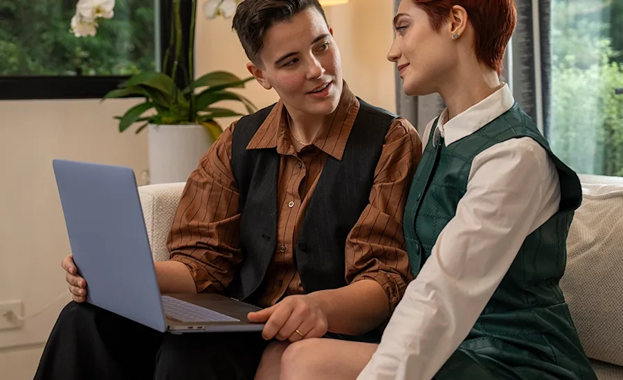A couple looking at a laptop screen.