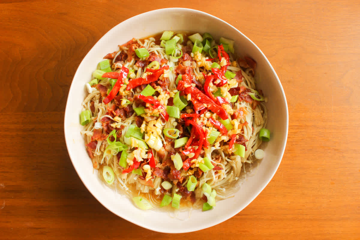 Green onions and sauce on enoki mushrooms and bacon
