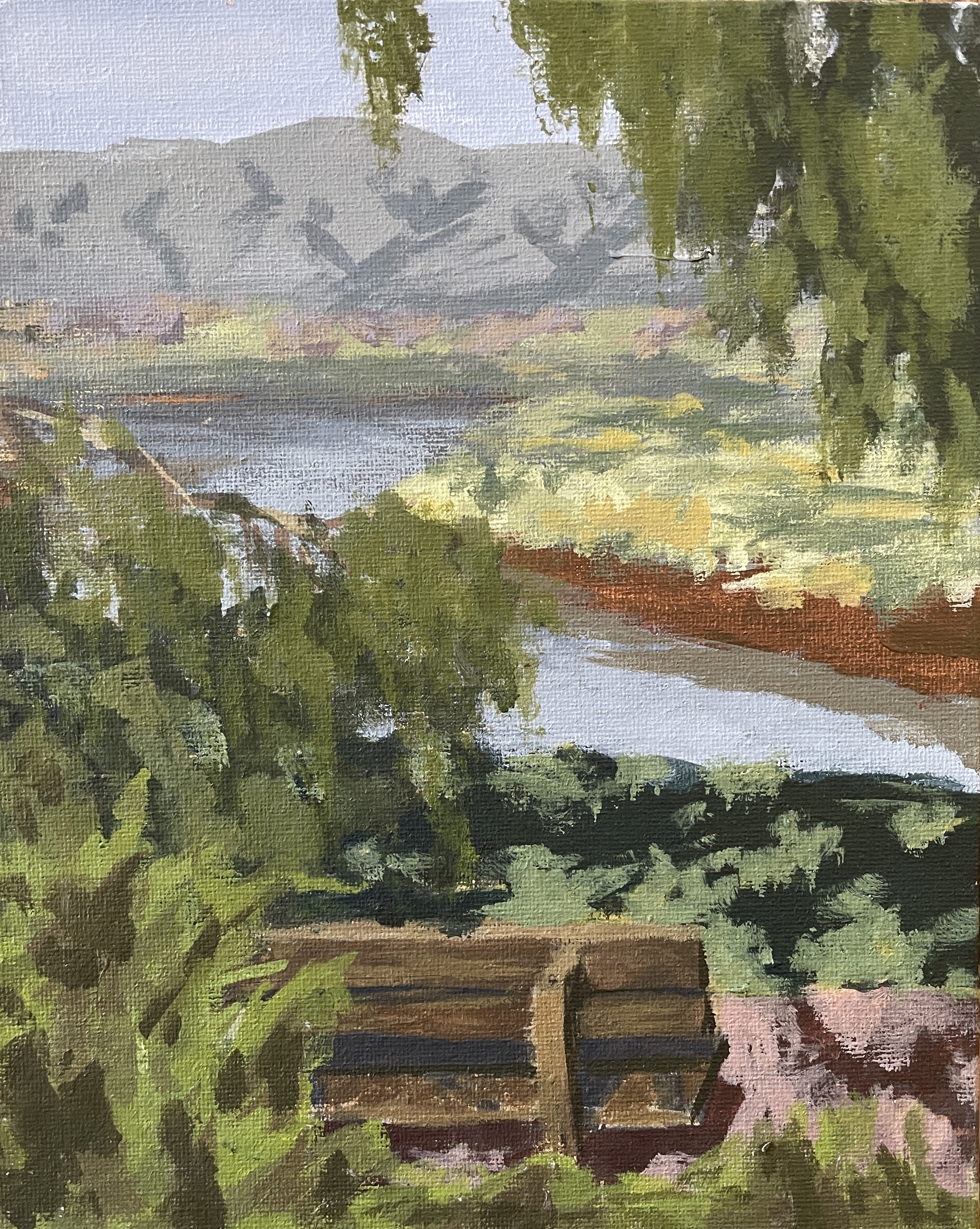 A painting of a bench overlooking a river with mountains in the background on a sunny day.