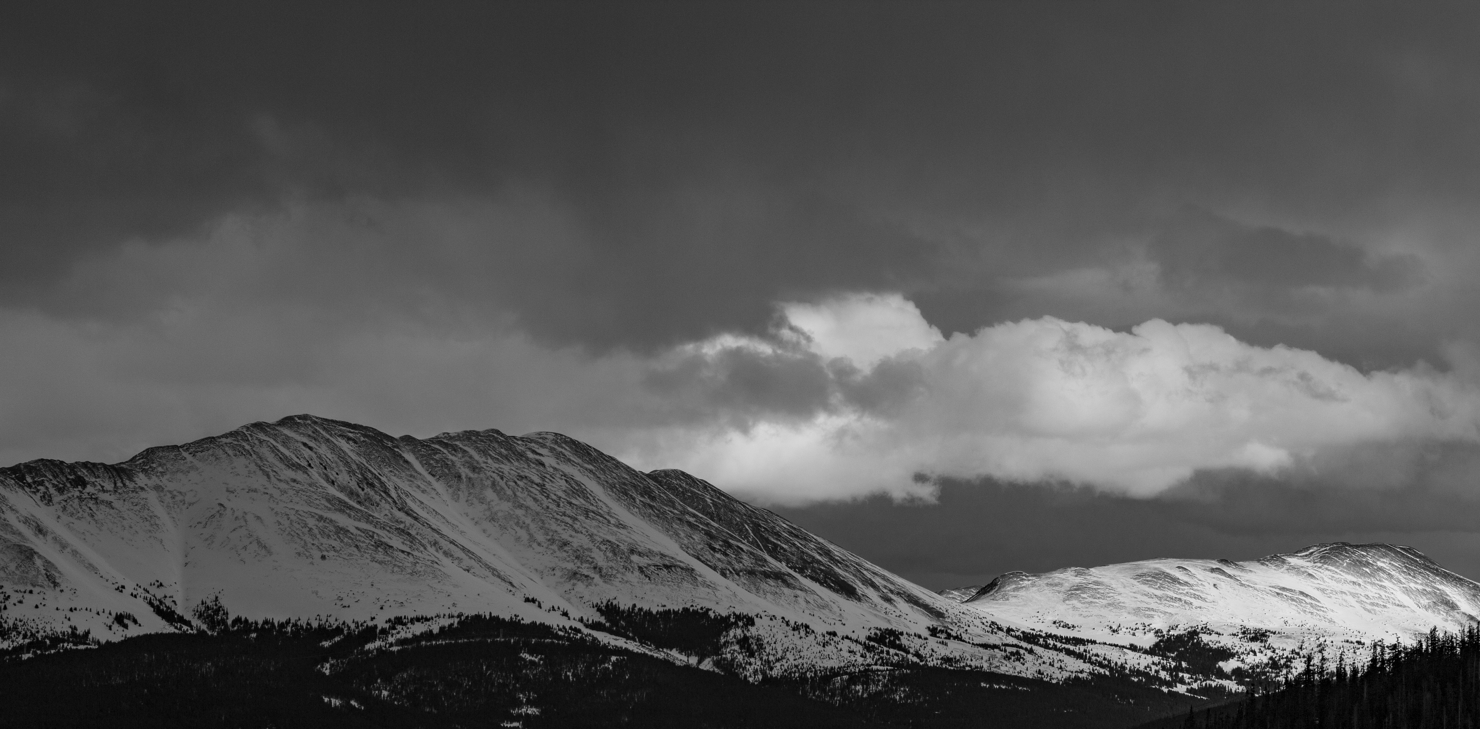 A photograph of the broad expanse of space around a big snowy mountain.