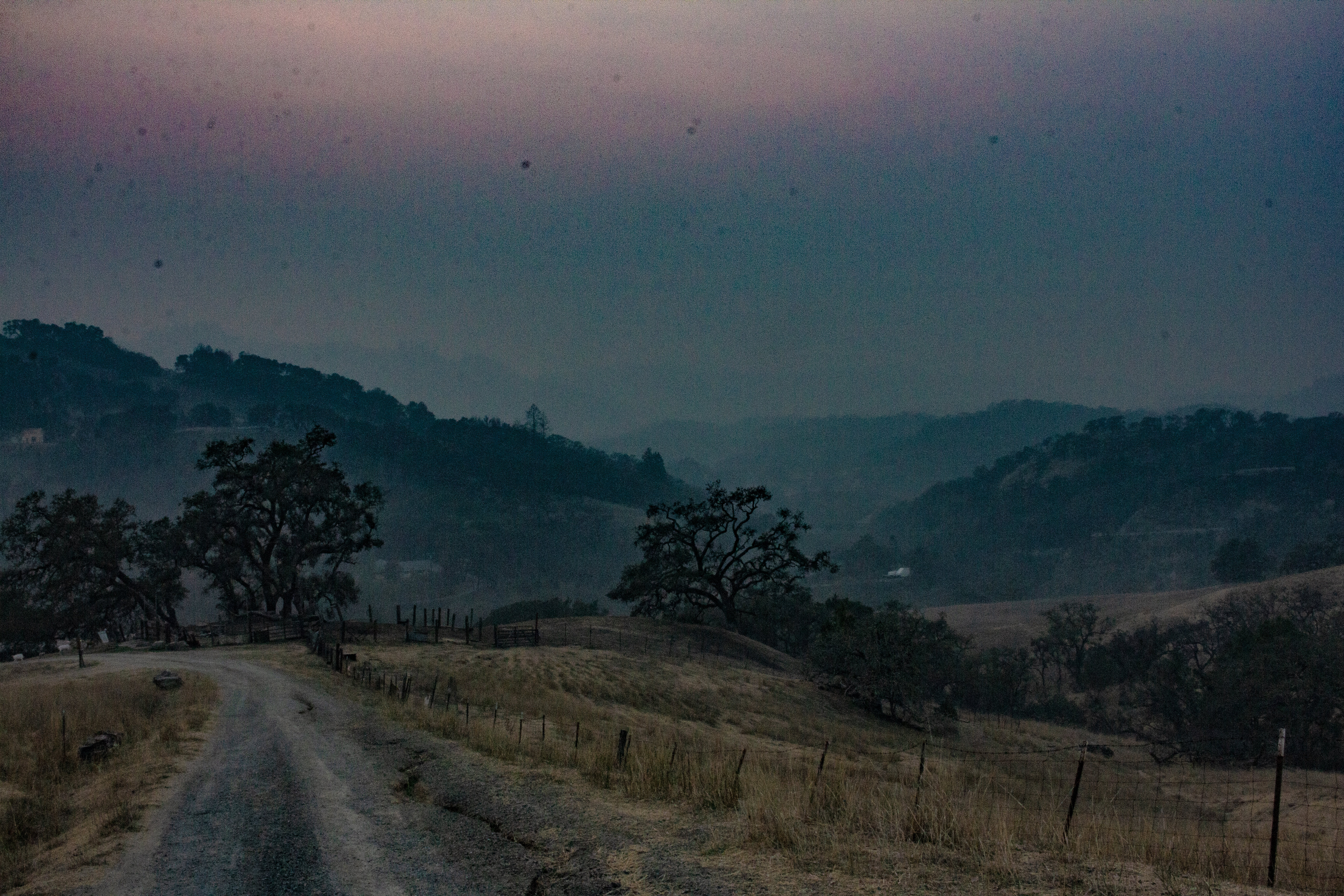 A photograph of the haze over a gravel road into a valley.