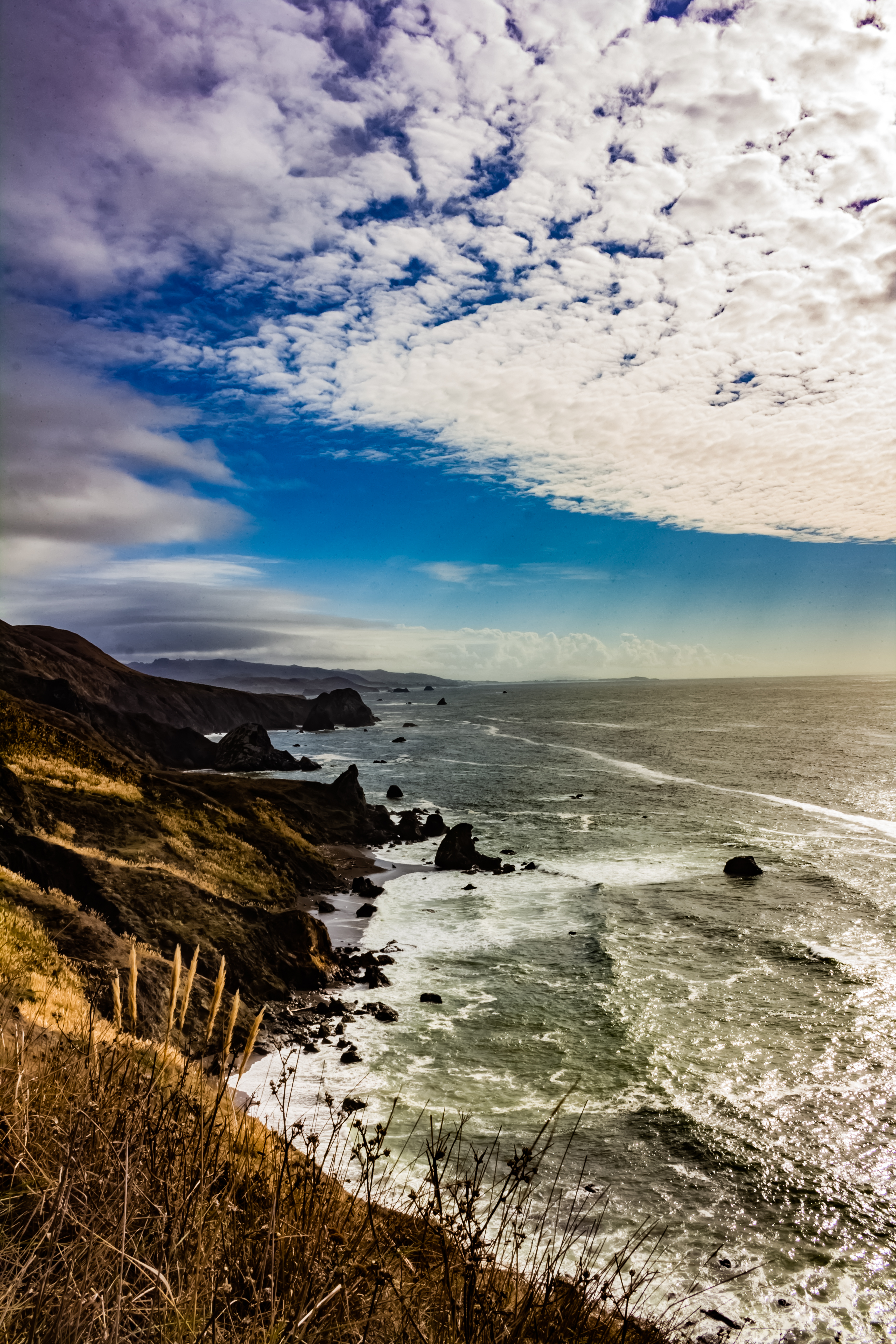 A photograph of the bluffs that overlook the ocean on a partly cloudy day.