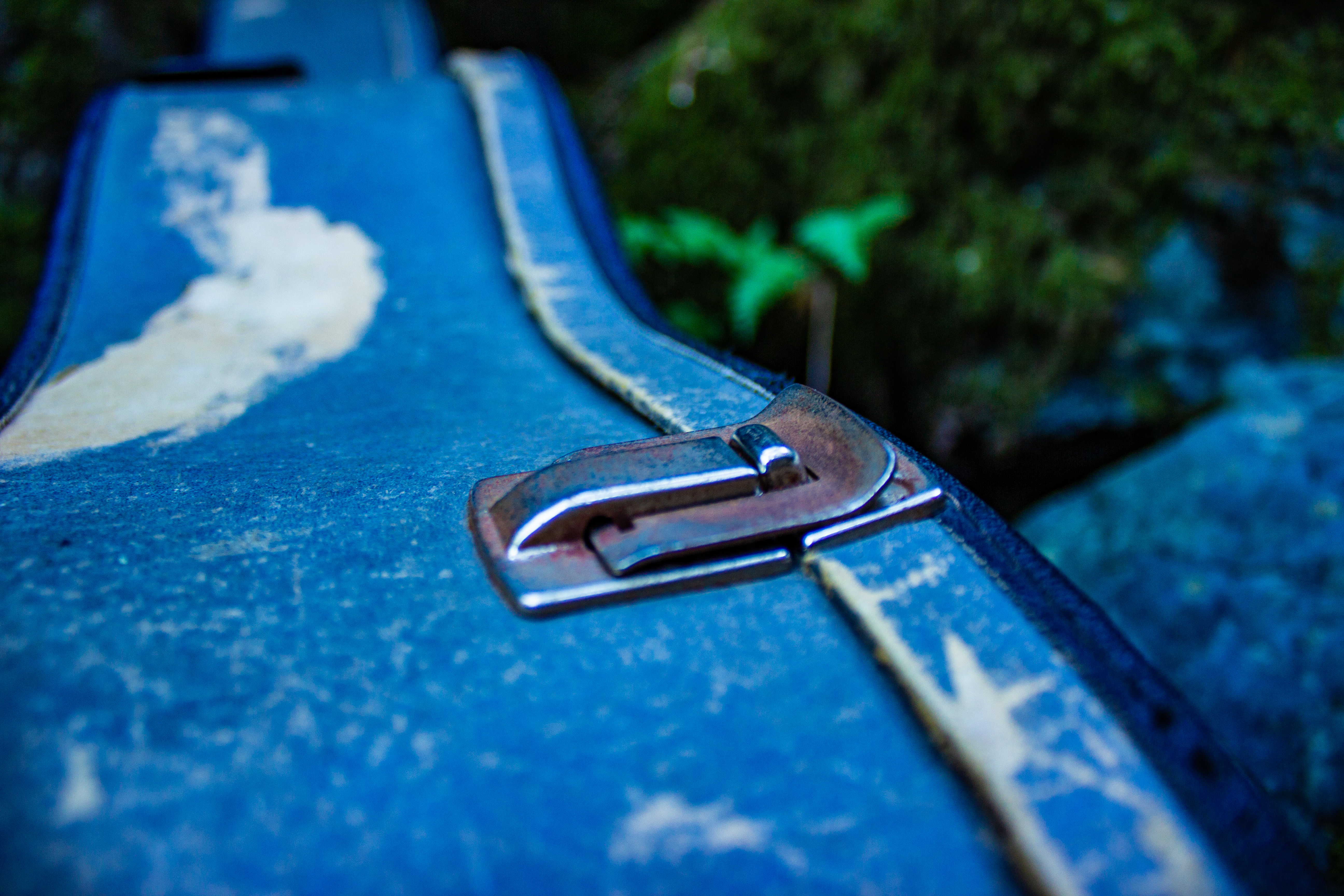 A photograph of a buckle on a guitar case.