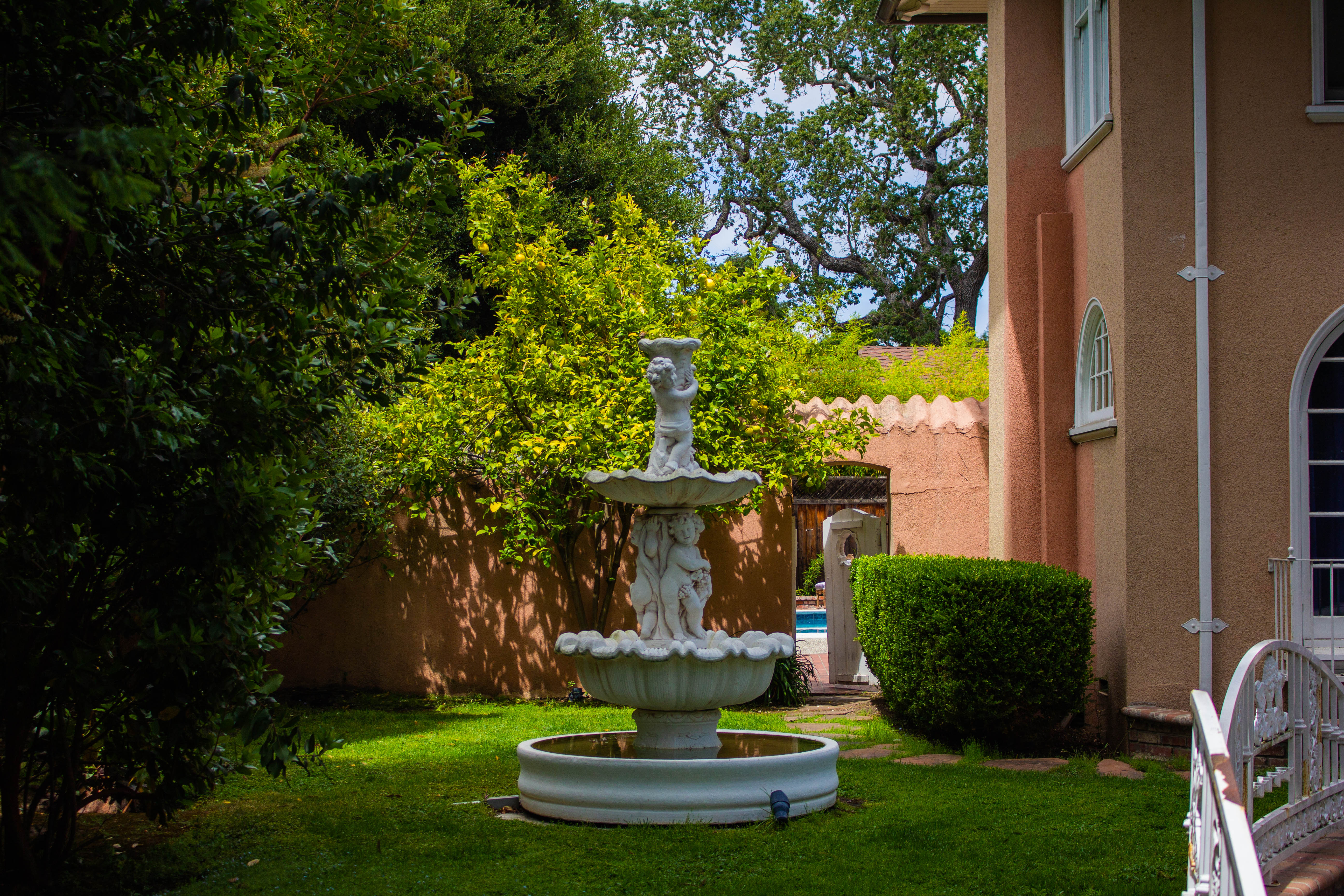 A photograph of a fountain next to a house.