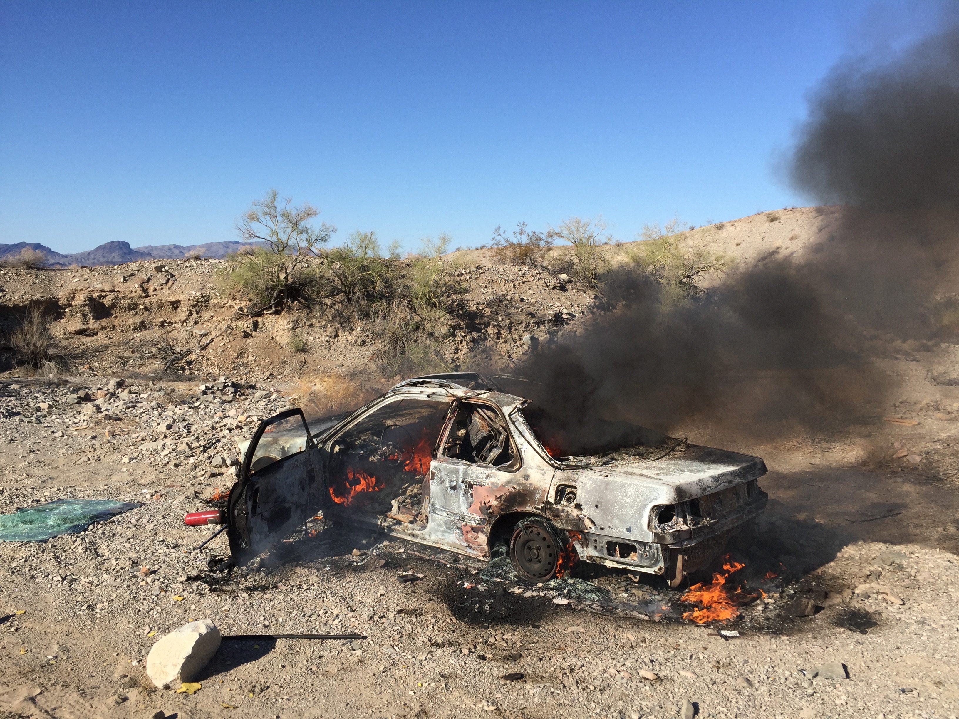 A photograph of the remains of a burning car.