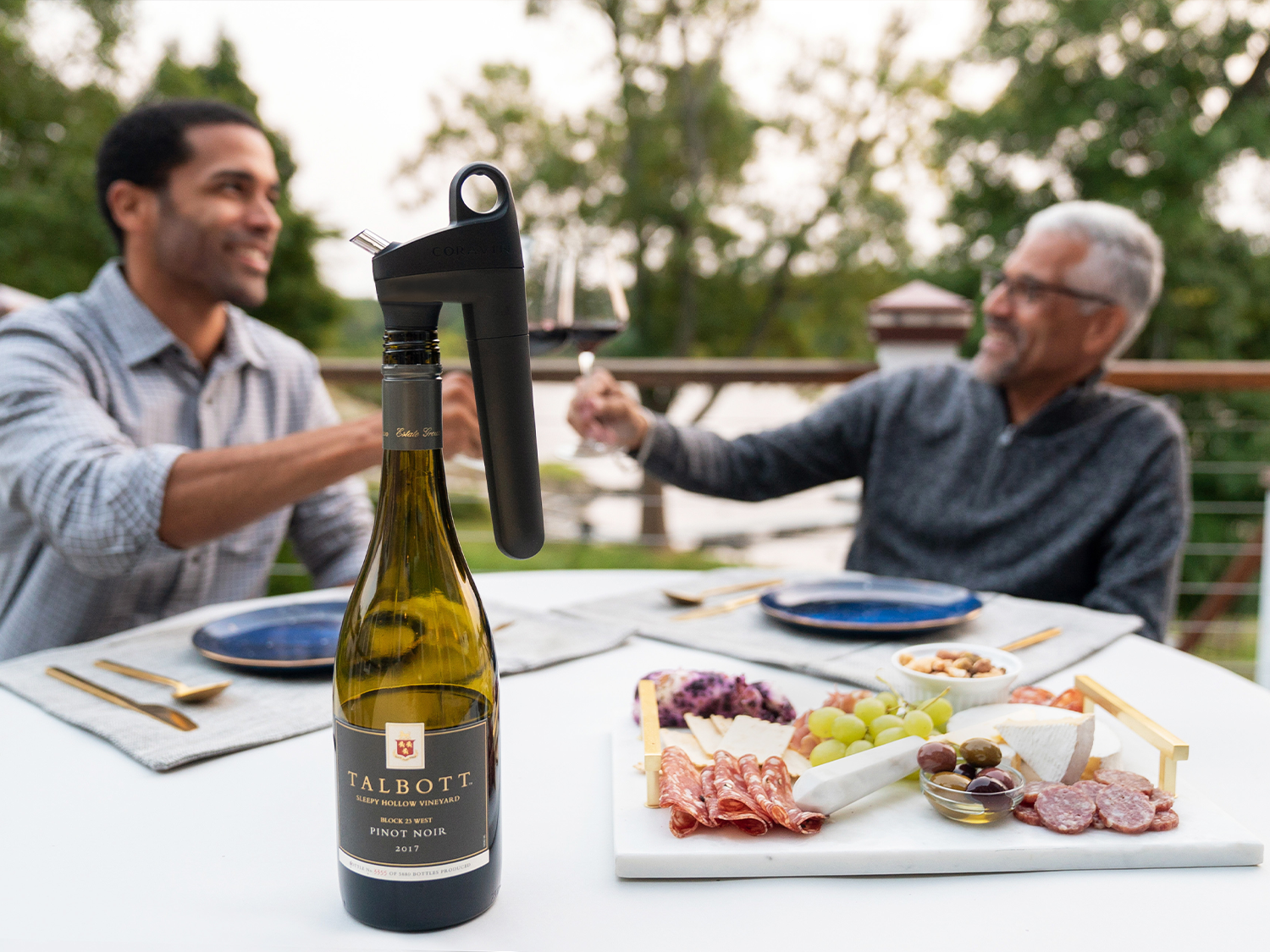 Pivot Wine Preservation System on bottle with man and son enjoying wine in the background