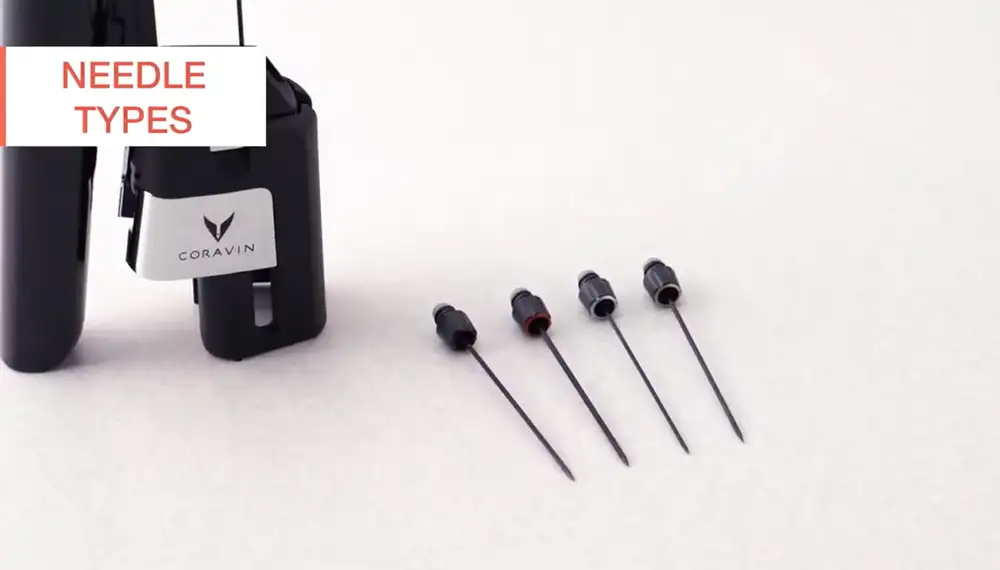 Coravin needles lying on a surface with a Coravin Model Six standing in the background.