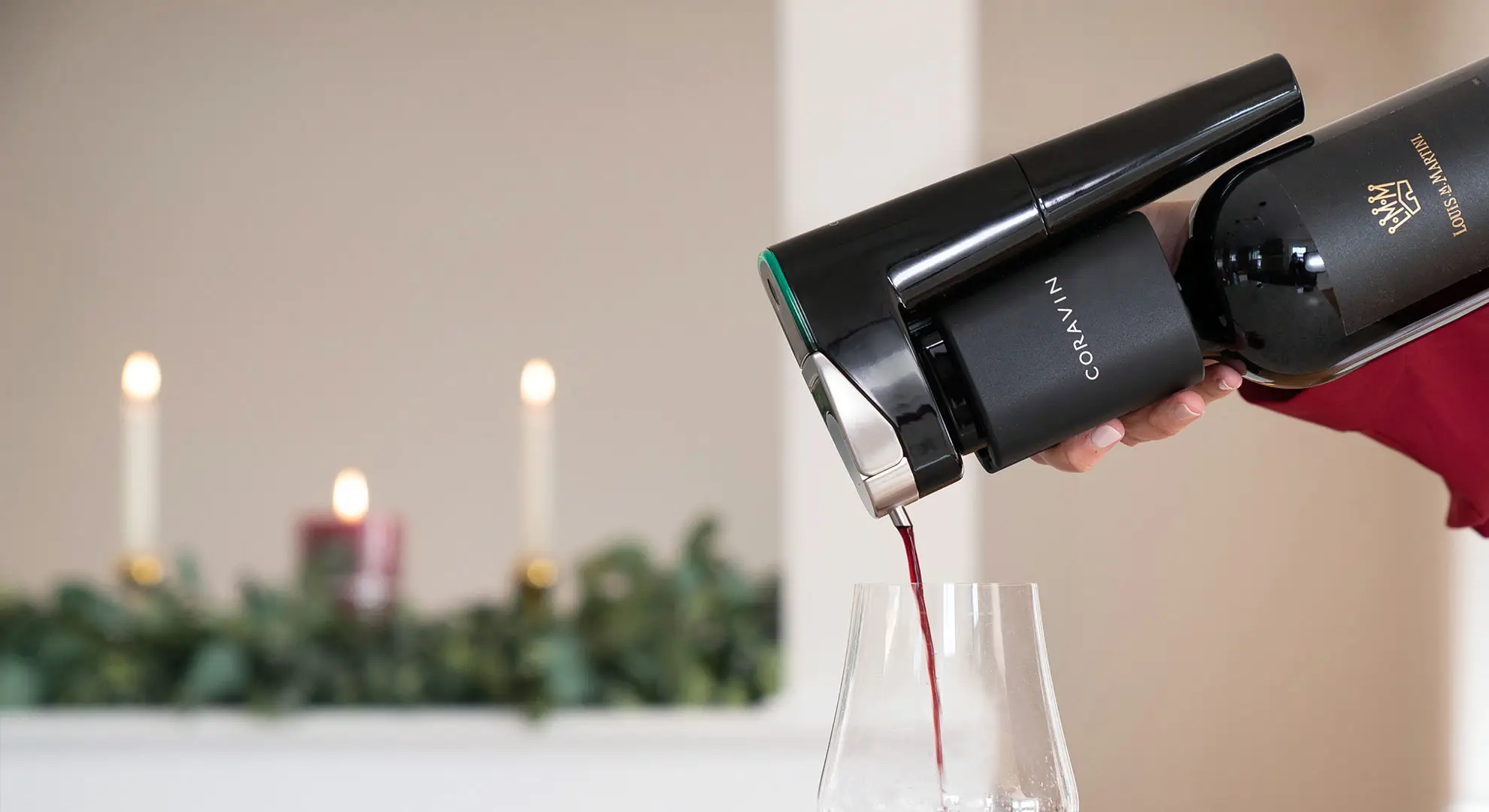 Pouring red wine with the Model Eleven Wine Preservation System in a holiday setting
