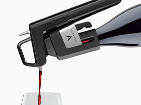 Close up product shot of a Coravin Model Six Wine Preservation System on the wine bottle pouring red wine into a wine glass.