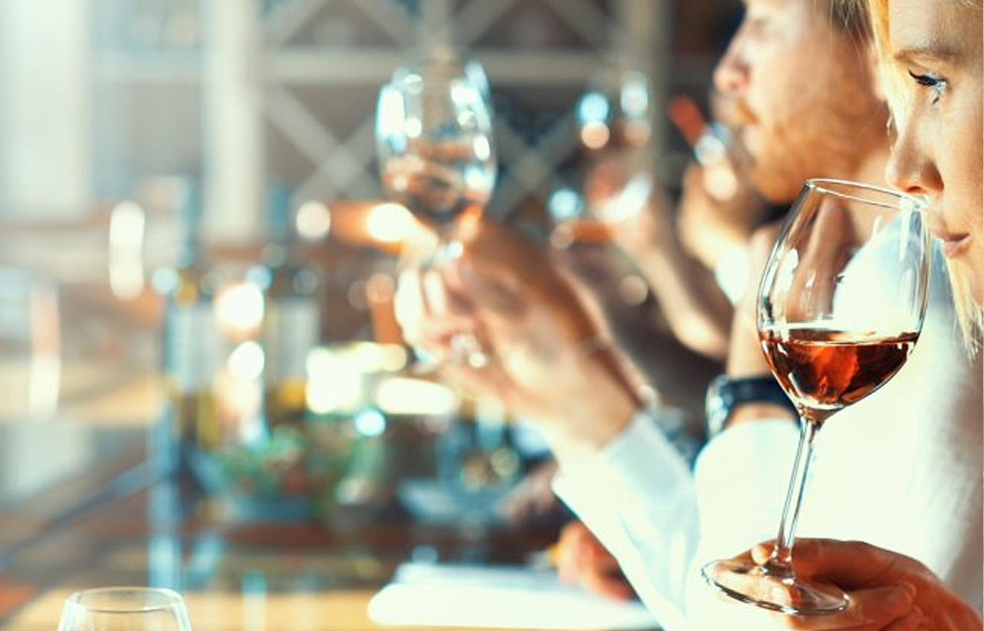 Plusieurs personnes qui participent à une dégustation de vin et chacune d’entre elles est en train de sentir le vin.