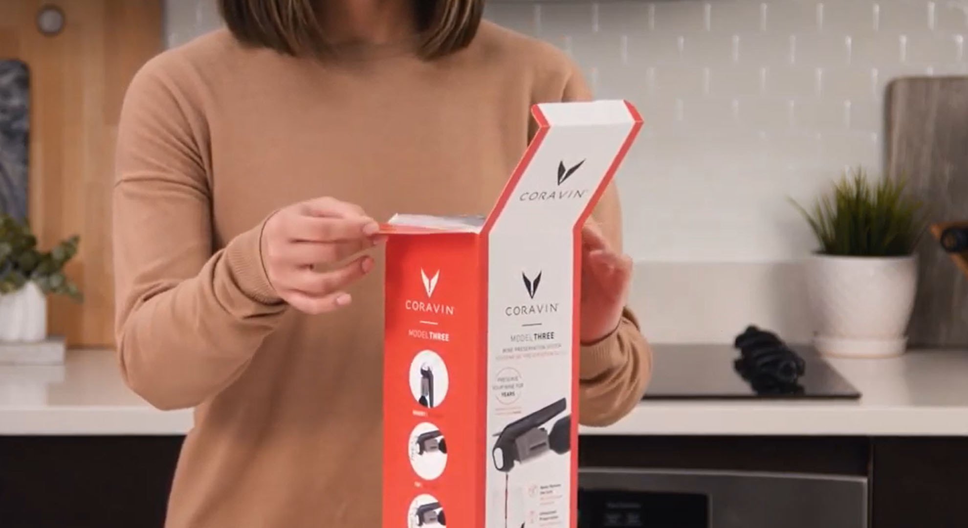 Donna che apre la confezione del sistema di conservazione del vino Coravin Model Three