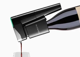Foto prodotto in primo piano di un sistema di conservazione del vino Coravin Model Eleven su una bottiglia che versa vino rosso in un bicchiere.