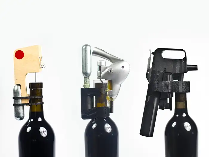 Diversi prototipi di Coravin su bottiglie di vino.
