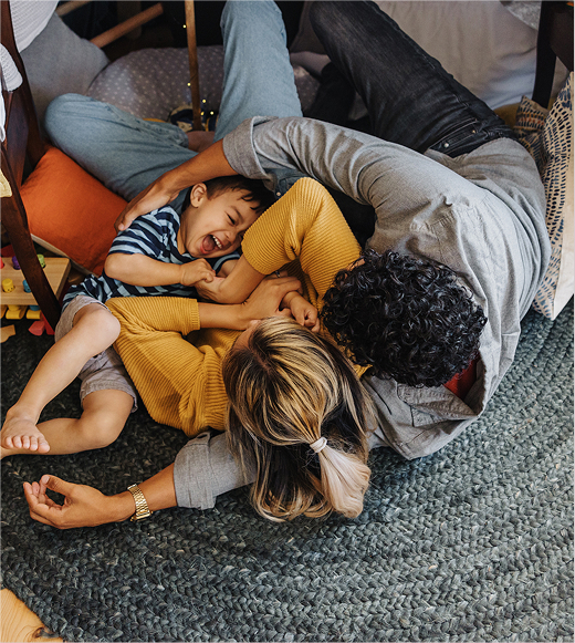 Picture of man and woman laying on ground with child