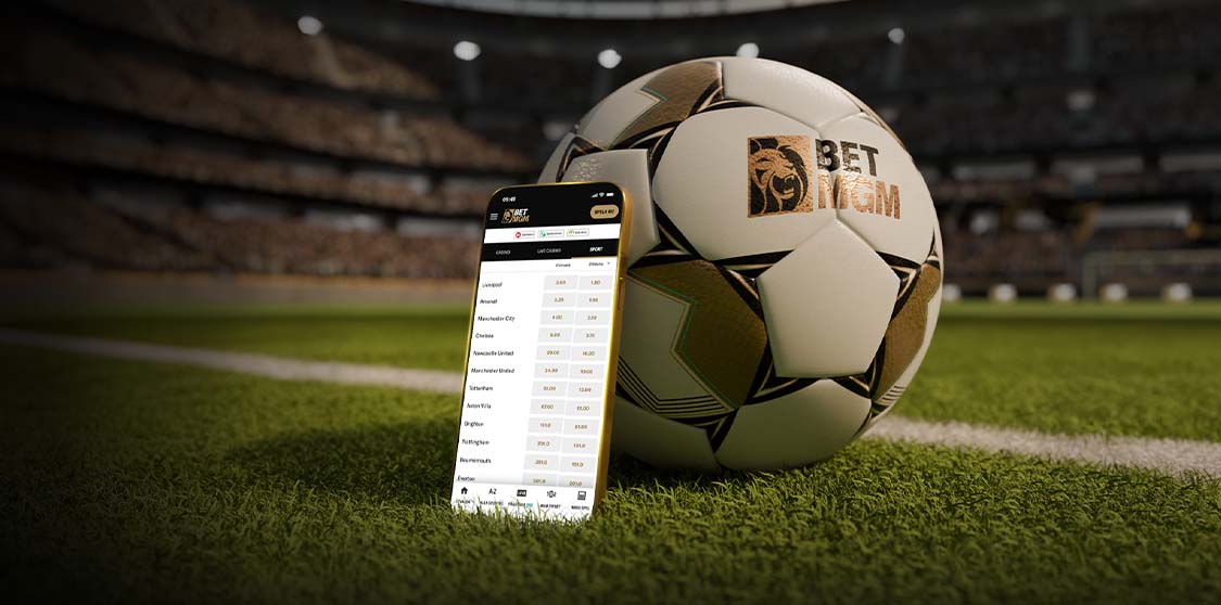 Mobil med sportodds bredvid en fotboll på en gräsplan.