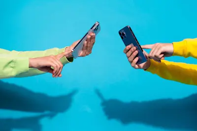 Dos personas acercan sus celulares para transferirse dinero con billetera virtual