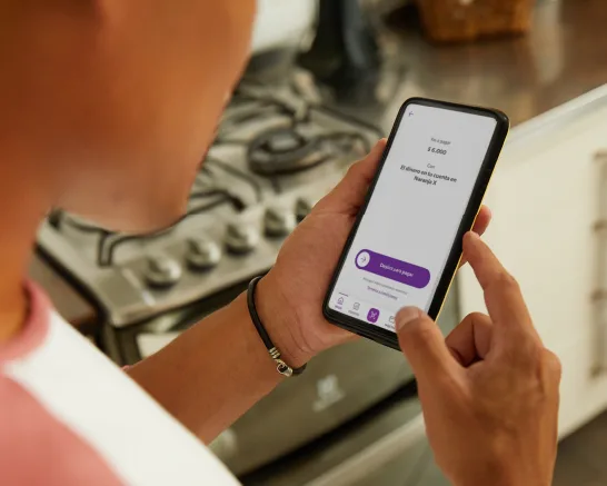 Teléfono celular con la interfaz de Naranja X con la feature de "Pagar resumen".