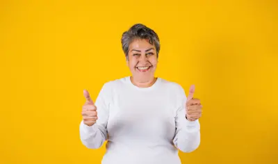Mujer sonriente hace pulgares arriba por la tasa de su Cuenta Remunerada