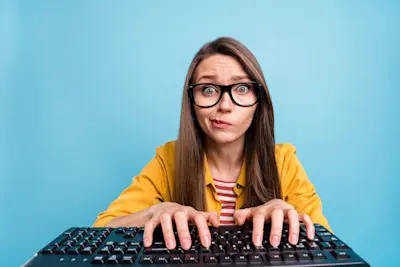 Mujer con anteojos escribe en el teclado y duda si una página es segura